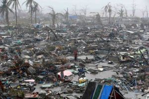People stand among debris and ruins of houses after Typhoon Haiyan pulverized the city of Tacloban.